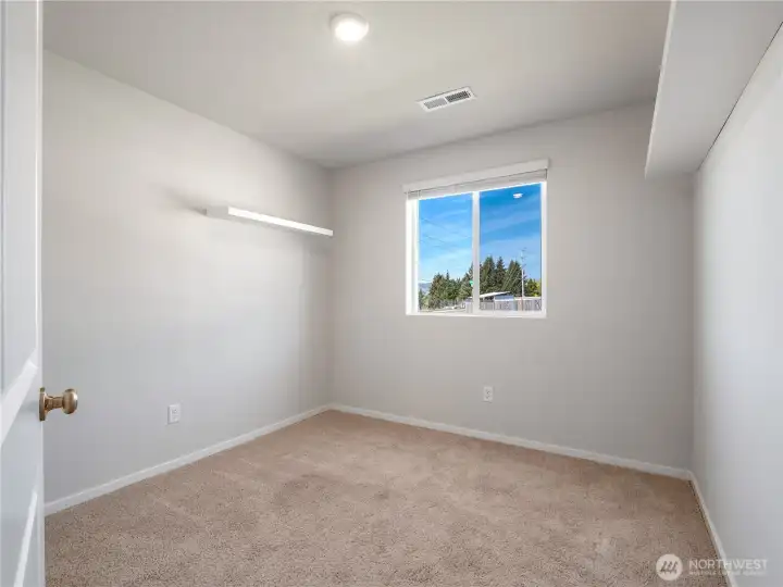 Front bedroom features built-in floating shelves and overlooks the fully landscaped front yard.