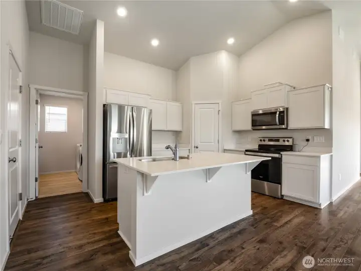 The modern kitchen offers everything you need: Stainless steel appliances, walk-in pantry, quartz countertops, and under-mount sink.