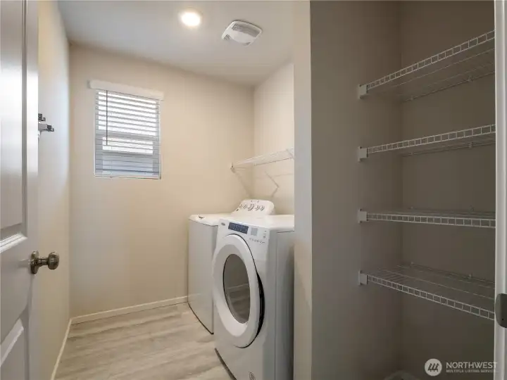 The convenient utility room, complete with washer and dryer, offers lots of storage options and is located just inside from the garage.