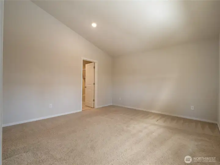 The private primary suite is spacious and features vaulted ceilings.