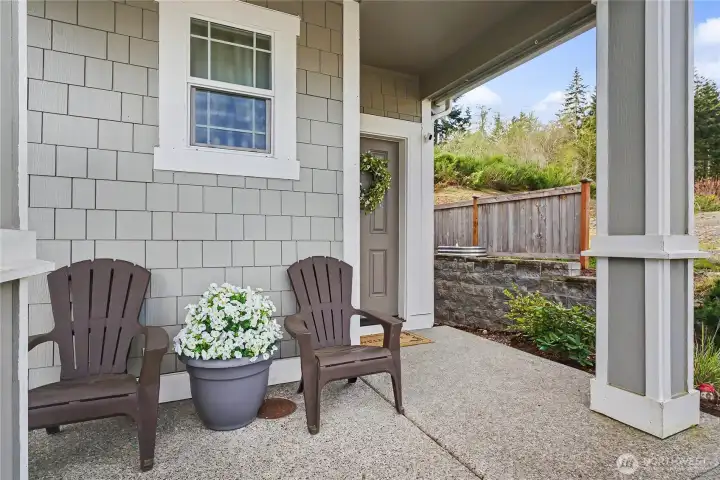 Inviting front porch with a peek of the open space to the right. The lot allows privacy on the west side.