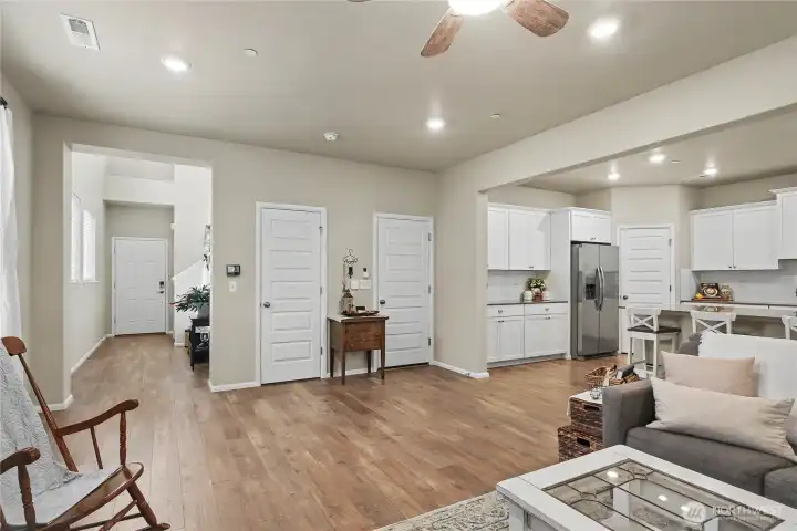 This angle of the great room shows the entry at the left of the photo.  The kitchen has many built-ins including the potential coffee bar to the left of the refrigerator. The walk-in pantry is to the right of the fridge.