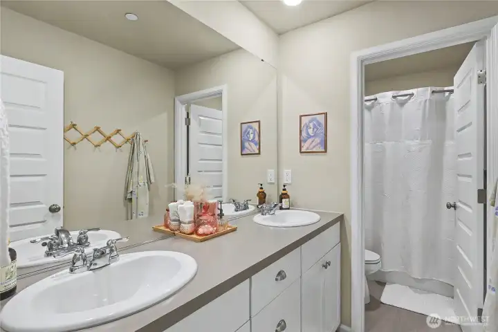 Bath off hallway with dual sinks.