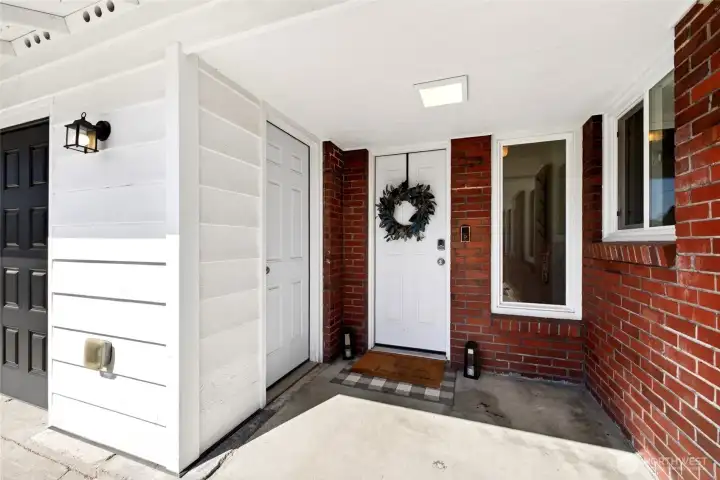 Cute side entrance (used primarily as a main entrance) features cute, covered area and access to storage area.