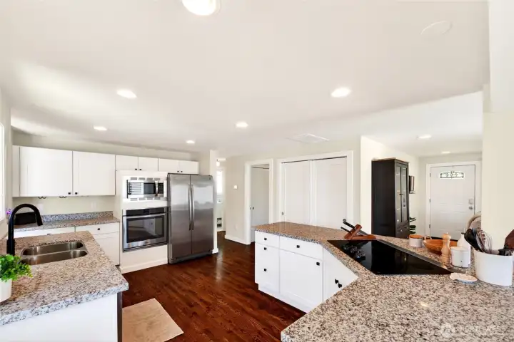 Kitchen features white cabinets, built-in stainless appliances and granite countertops.