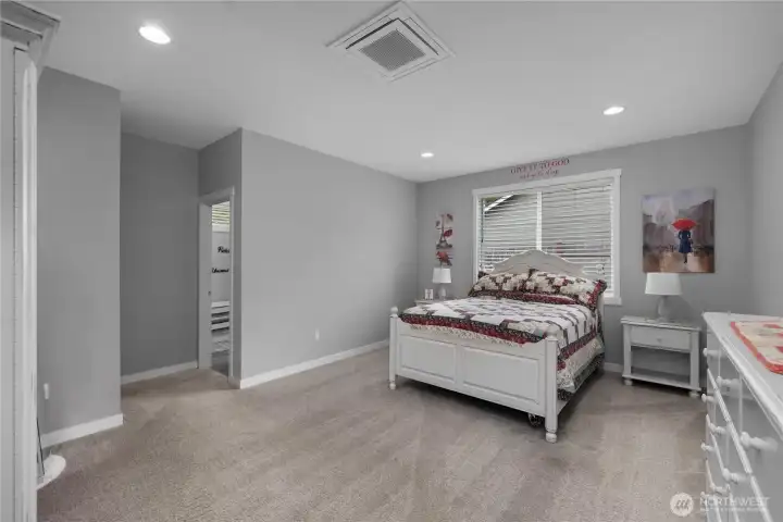 Primary suite with generous bedroom space, recessed lighting, carpet, and private bath access.