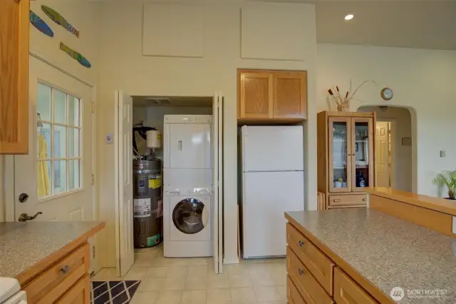 Kitchen view to the laundry & utility closet with storage above.