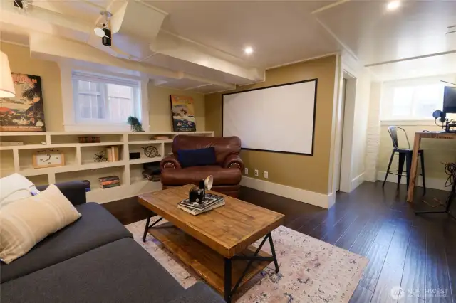 L-shaped and floored in engineered plank, the media/rec room also includes a small corner that is currently a hideaway office, but has potential to house a wine collection. Built-in shelving could also accommodate the needs of a small library.