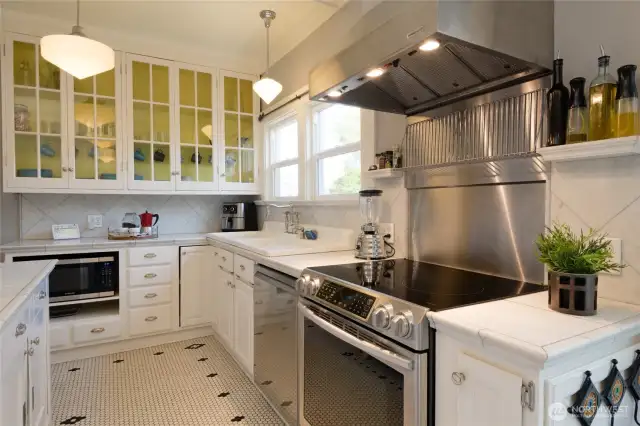 Brightly lit and decorated in black and white, the chef's kitchen is centered around the newly installed induction range. If you haven't tried out this tech, you're going to love it! Faster heating than natural gas, while being much more environmentally friendly and infinitely more adjustable, it's quickly becoming the choice of professional chefs. Generous storage and workspace makes this a hub for creativity and entertaining.