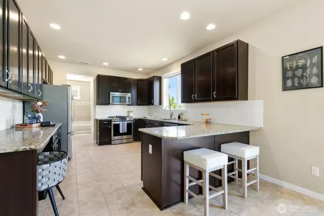 Large kitchen offers breakfast bar and stainless appliances.