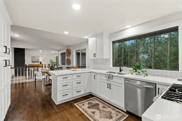 Light-filled and open, this beautifully updated kitchen showcases new backsplash, abundant counter space, a built-in microwave, and a 30-inch five-burner gas range—designed to cook, gather, and entertain with ease.