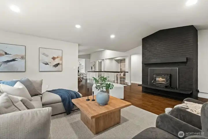 Bright, airy open-concept living room with wood-burning fireplace.