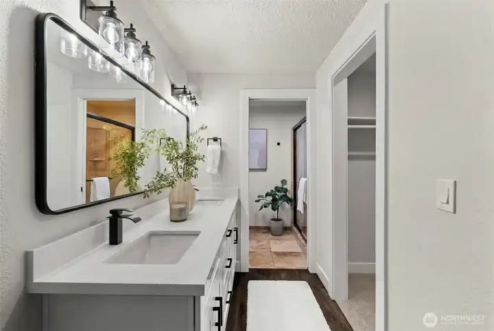 Spacious primary bath featuring updated shower and tiling, double sinks, and walk-in closet.