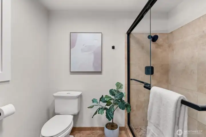 Shower with modern sliding glass door for convenience.