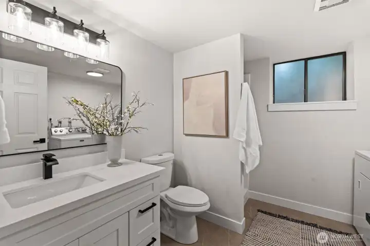 Modern, spacious three-quarter bathroom with washer and dryer.