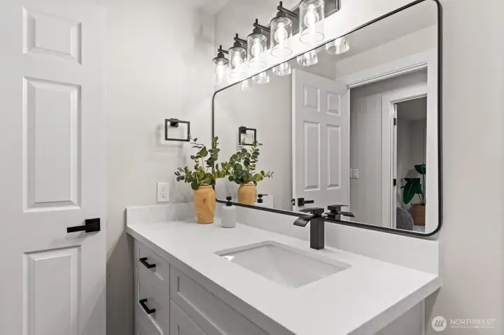 Updated upstairs bath featuring modern lighting and oversized mirror.