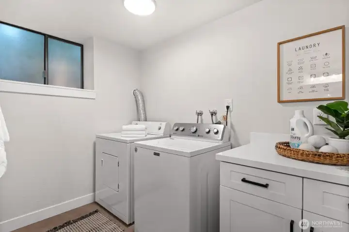 Downstairs washer and dryer tucked away for quiet operation, with added cabinetry for storage and folding