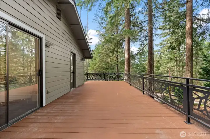 Spacious upstairs deck with entry from kitchen, primary suite, and a ground-level stairwell.