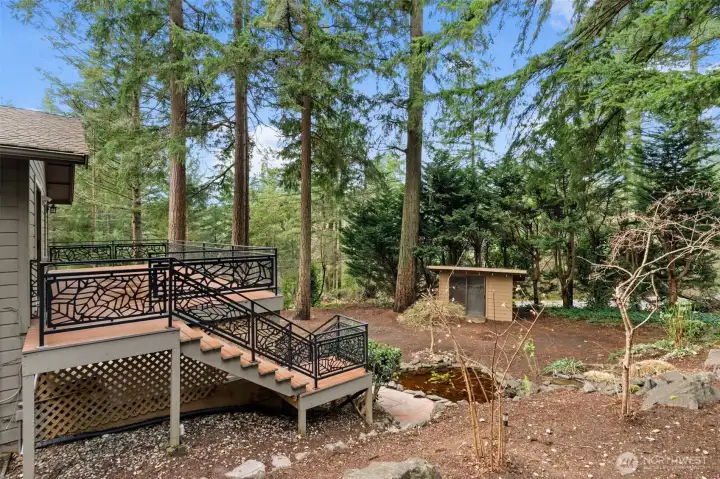 Attractive stair railing with bonus storage shed and a quaint pond in the backyard.