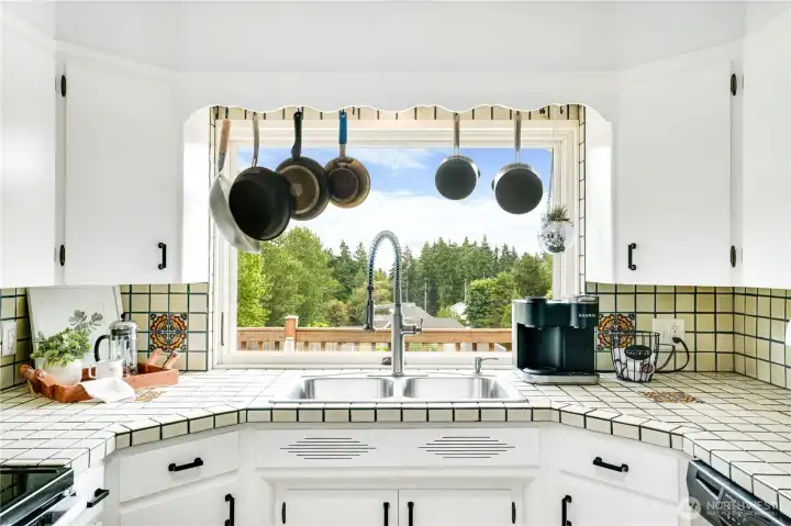 Picturesque views right from your kitchen sink! Freshly painted cabinets and updated hardware breathe new life into timeless details, creating a space that’s equal parts classic and refreshed.