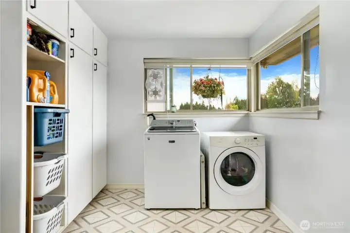 The convenient laundry room offers generous storage or a bonus pantry, and easy outdoor access to the right, which leads to the detached garage - making grocery runs a breeze.