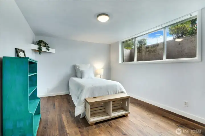 Large window, luxury vinyl flooring, and updated millwork—this flexible bedroom feels light, open, and effortlessly modern.