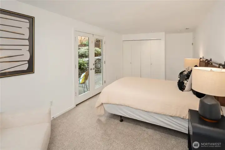Downstairs secondary bedroom. French doors open to backyard patio space