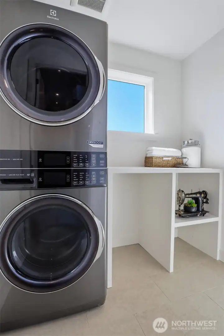 2nd floor laundry room with shelving and a counter to fold clothes.