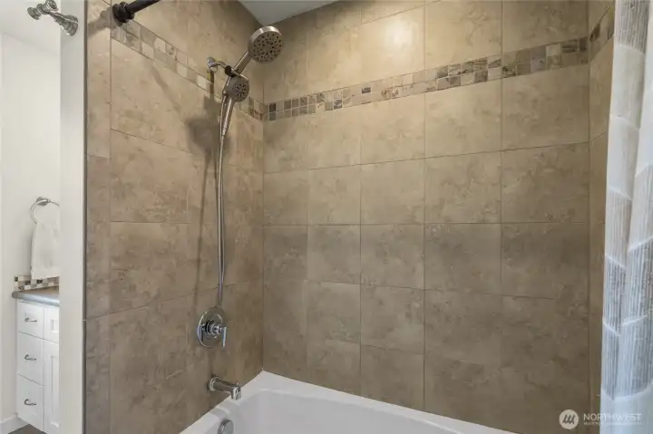 Tiled surround in the full bathroom off the primary bedroom Tiled surround in the full bathroom off the primary bedroom