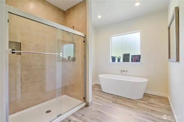 Large tiled shower with glass doors.