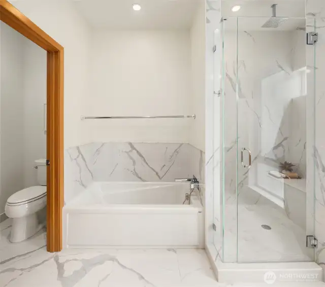 A view of the soaking tub and water closet in the primary bathroom.
