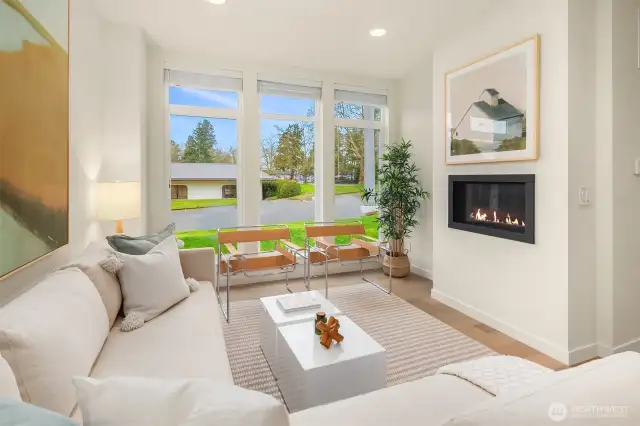 The gas fireplace is the focal point of this cozy space. Notice the floor-to-ceiling windows.