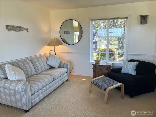 The living room is surrounded by large windows creating a light airy atmosphere.