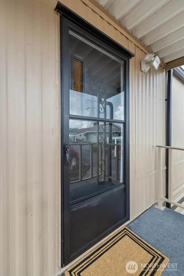 Front door, faciing north, with glass screen door for letting the light in.