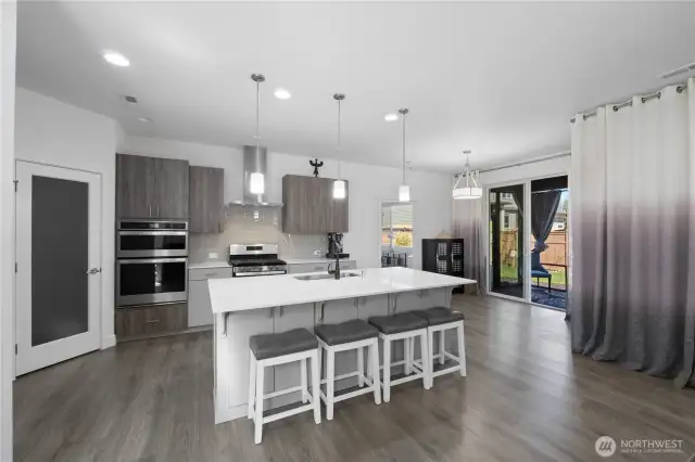 ~The gourmet kitchen is a chef’s dream—highlighted by custom cabinetry, quartz countertops, stainless steel appliances, a large island, and a walk-in pantry~