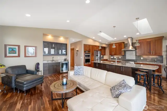 Living Room offers Vaulted ceilings, Acacia Floors, Entry point to deck via four panel french doors, Rock faced gas fireplace, and a wet bar.