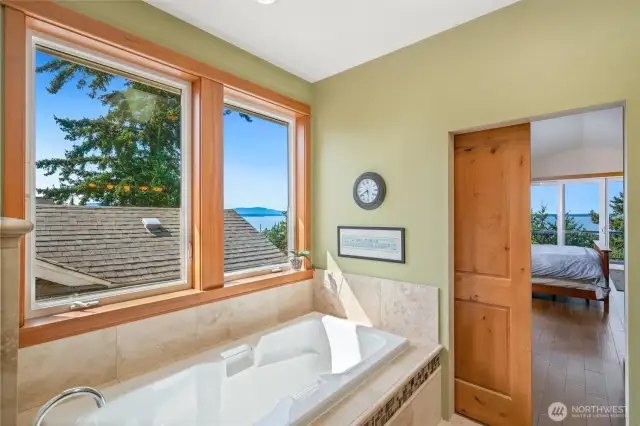 Primary En suite soaker tub under beautiful fir trimmed windows with beautiful heated travertine tile work.