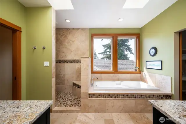 Primary En Suite with a walk in shower, dual sinks and a soaker tub trimmed in beautiful heated Travertine tile.