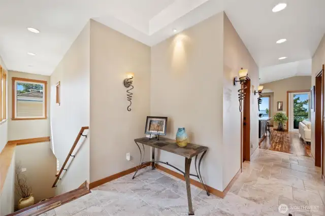 Welcoming entry with custom lighting, elegant tile floors, and a glimpse of bay views just beyond.