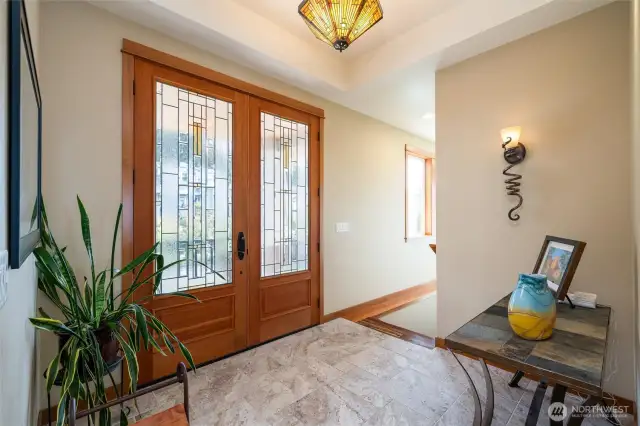 Welcoming entry with custom lighting, elegant tile floors, and a glimpse of bay views just beyond.