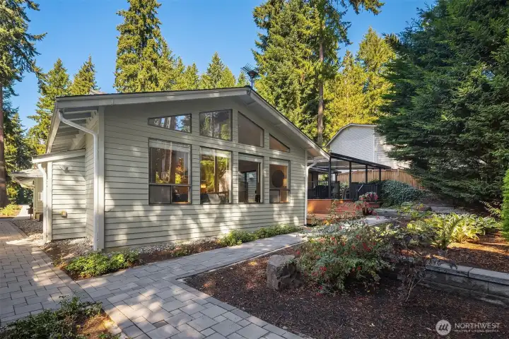Landscaped backyard with paver walkway and storage shed.