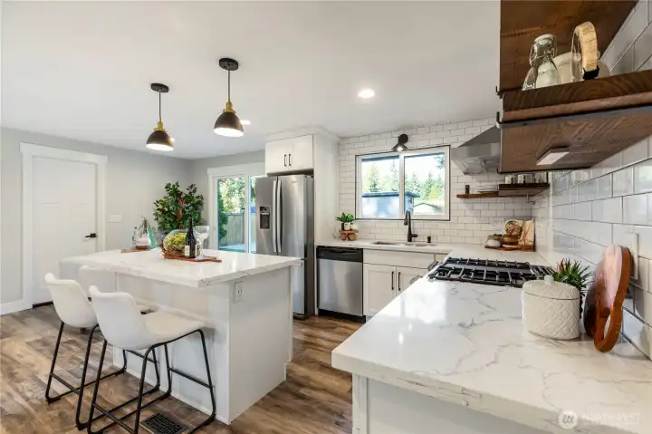 Subway tile backsplash, and a spacious island with seating.