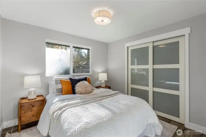 2nd bedroom with natural light and a neutral color palette. Built in shelving included inside closet.