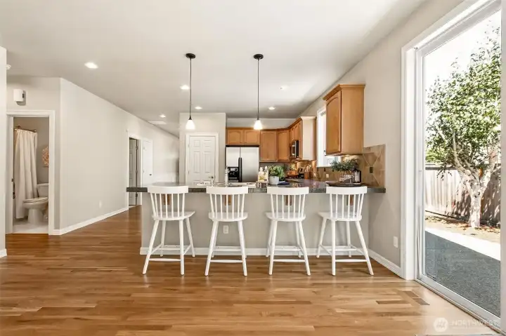 A generous eating bar offers casual dining and extra prep space. Perfect for morning coffee, homework time, or hosting friends. A bright kitchen dining nook opens directly to the back patio, making it effortless to enjoy meals inside or step out for fresh air. A generous eating bar offers casual dining and extra prep space. Perfect for morning coffee, homework time, or hosting friends. A bright kitchen dining nook opens directly to the back patio, making it effortless to enjoy meals inside or step out for fresh air.