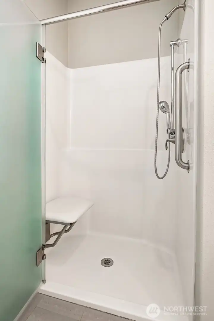 The walk-in shower with dual grab bars and a fold-down seat provides accessibility when needed. Buyers seeking single-level ease will value this rare feature. Not needed, fold the chair up and out of the way. The walk-in shower with dual grab bars and a fold-down seat provides accessibility when needed. Buyers seeking single-level ease will value this rare feature. Not needed, fold the chair up and out of the way.
