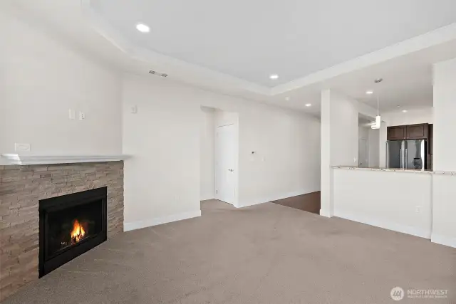 Living room with gas fireplace open to the kitchen.