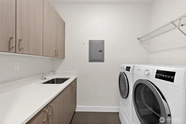 Laundry room with storage, laundry sink and ductless dryer.  Washer and dryer stay with the home.