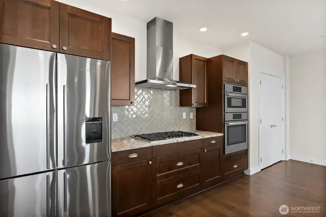 Newer refrigerator. The pantry doors are to the right of the stove.