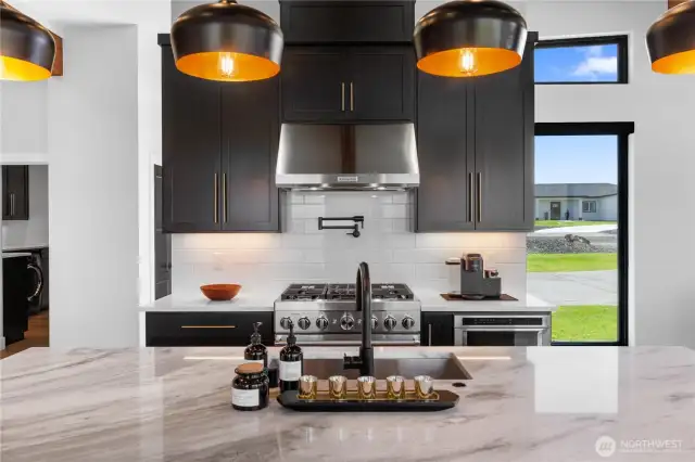 Pot filler faucet above kitchen stove.