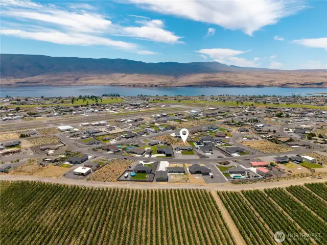 Aerial view of home with orchards backing and facing Columbia River.